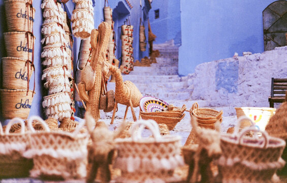 Wicker baskets and goods displayed on blue walls in Chefchaouen