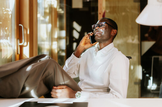 Relaxed professional taking a phone call in office