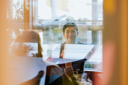 Business meeting through glass reflection in modern office