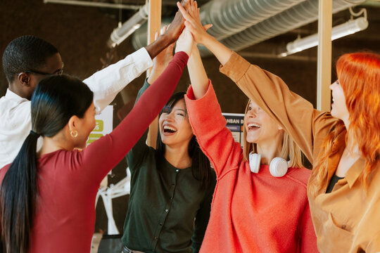 Multiethnic team celebrating success with high fives