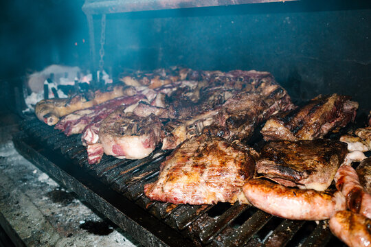 Traditional argentine asado cooking various meats on grill
