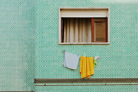 Colorful towels hanging on a tiled wall exterior