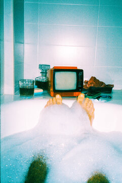 man bathing in a bathtub filled with foam, 35mm film