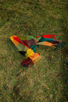 Colorful scarf lays on grass during bright daylight