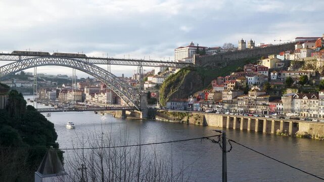 Wide view of the Dom Luis I Bridge and Ribeira waterfront from across the Douro.