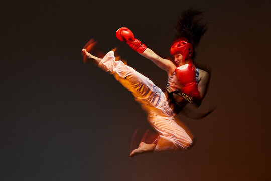 Karate athlete performs high kick in a training session indoors