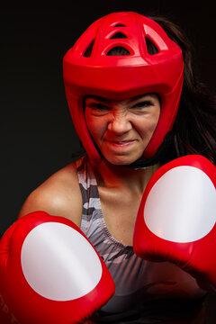 Female boxer practices in training gear and red gloves
