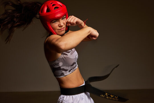 Young athlete practices martial arts in training gear indoors