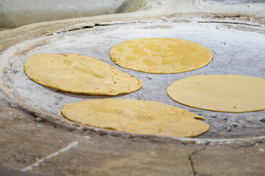 Mexican tortillas cooking on traditional comal surface