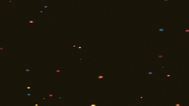 A dark background scattered with bright, colorful specks resembling distant stars