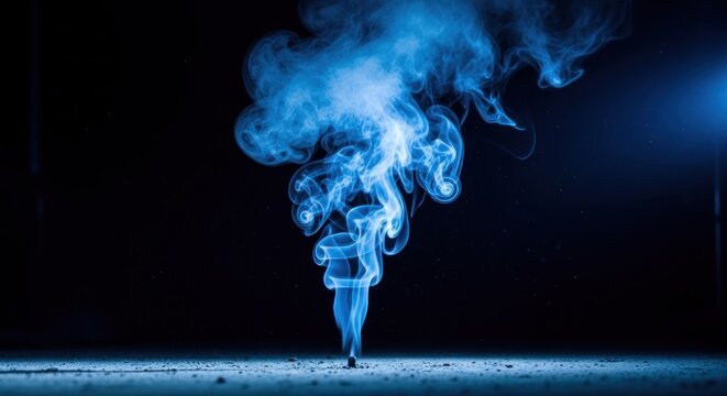 Blue swirling smoke billows from a dark surface against a black background