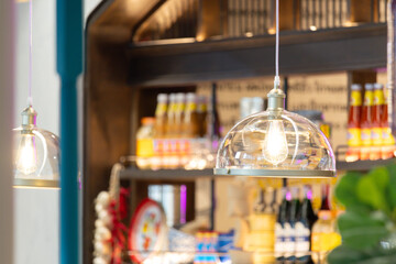 A lighted glass lamp hangs over a shelf of condiments