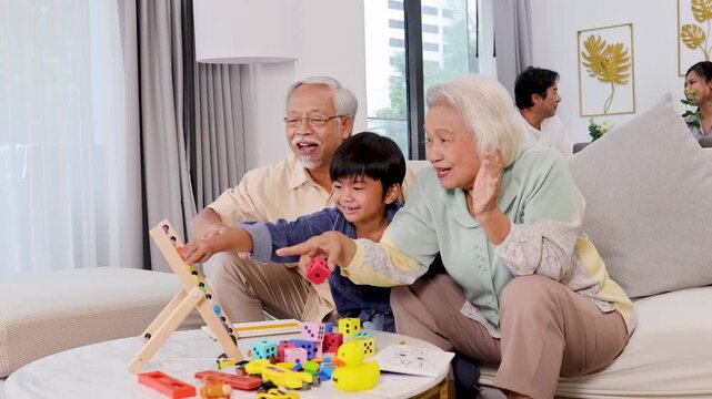 Grandparents and Grandchild Playing Educational Math Game at Home