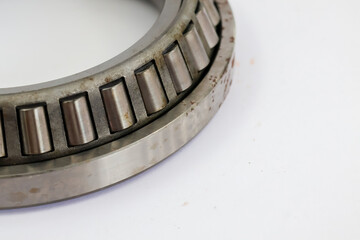 Close up of industrial tapered roller bearing assembly with steel rollers isolated on white background professional mechanical part for heavy duty machinery.