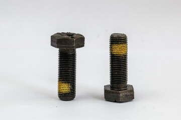 Two heavy duty industrial hex bolts with yellow thread locker coating isolated on white background.