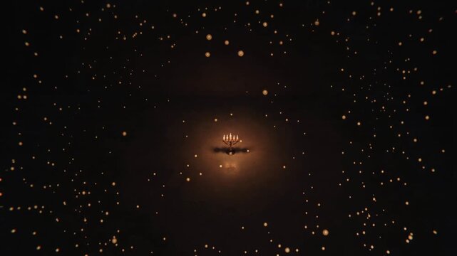 A bronze candelabra with seven lit candles glowing in the dark, casting warm light and shadows on a textured surface. Concept of vintage, antique, and ambient lighting.