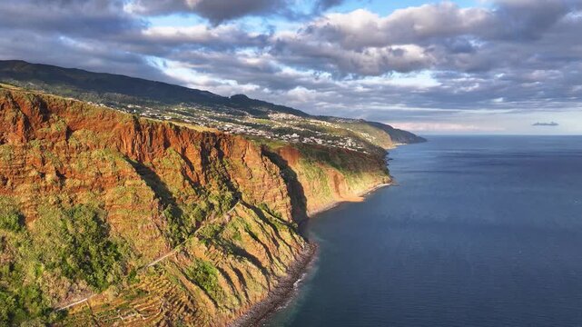 Sunset aerial view of coastal road and tunnel towards Calheta on Madeira coast