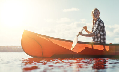 Obraz premium Vacation, woman and thinking with canoeing on lake for travel adventure, fun activity and reflection. Sunshine, person and thoughtful in row boat for holiday trip, exploring nature and weekend break