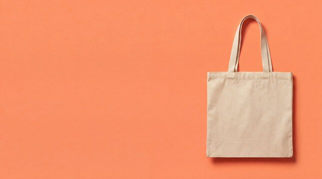 Canvas tote bag on orange background. Tote bag mockup with copy space for earth day promo, plastic free july campaign, sustainable retail branding, tote bag design, summer sale theme