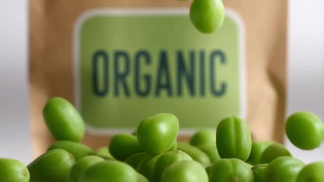 Slow motion of peas falling against a blurred background in front of a focused organic label on a bag concept for direct organic product branding and promotion