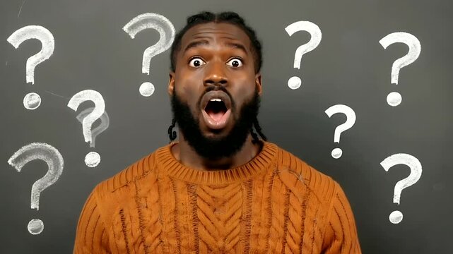 Surprised African American man with dreadlocks and open mouth, surrounded by white question marks on a dark chalkboard background, expressing confusion or shock