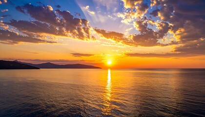 Dramatic sunset over calm ocean with colorful clouds and sun rays