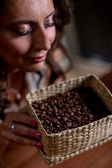 Calm smiling woman, Peaceful lady holding beans gently, Relaxed woman with basket and soft expression, Serene female figure with beans beneath gentle shadow lighting