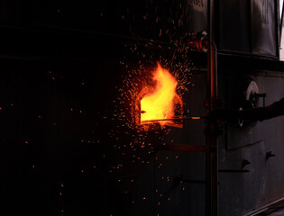 Obraz premium The workers are stirring the coal in the boiler.