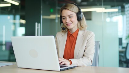 Woman working on laptop with headset