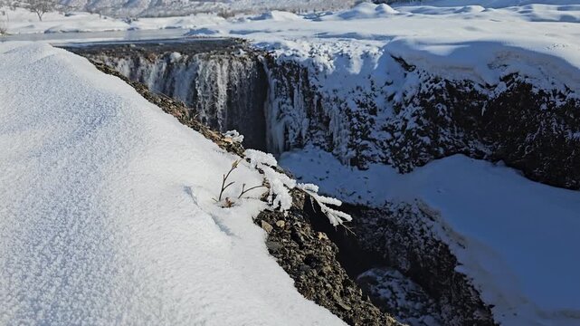 A winter waterfall drops into a snowy gorge, surrounded by frozen terrain and distant mountains under a clear blue sky.
📍Marivan, Kurdistan 