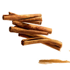 Piled, curled, brown cinnamon sticks, some angled, isolated against black