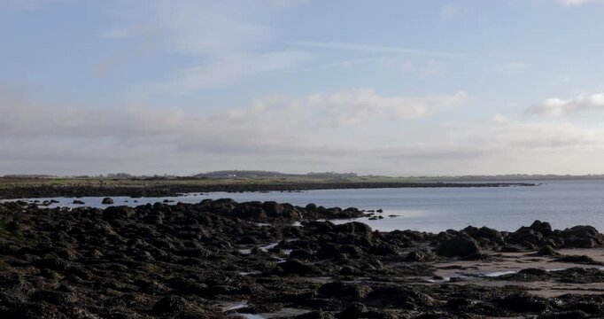 Establishing shot of the intertidal rocky shore and coastline of Galway Bay, a peaceful seascape and the natural beauty of the Irish shoreline