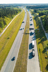 Fototapeta premium Drone shot above a motorway through green forest