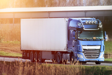 White transport lorry driving along rural road