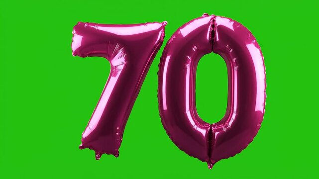 Close up of pink foil balloon number 70 on green screen