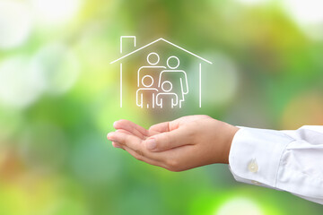 マイホームと家族のアイコンを包む子どもの手