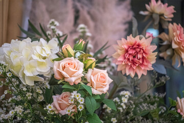 A bouquet of multiple flowers with a pink rose in the center, Valentine's Day.