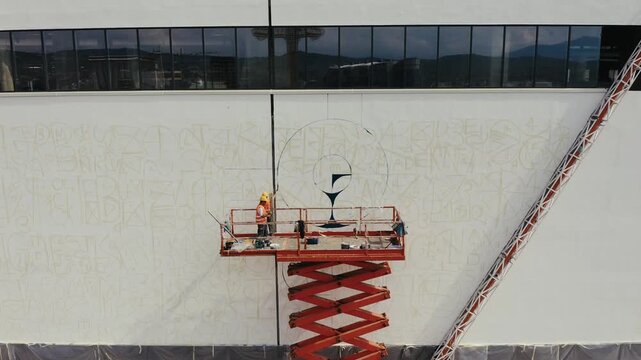 Mural artists painting a building facade
