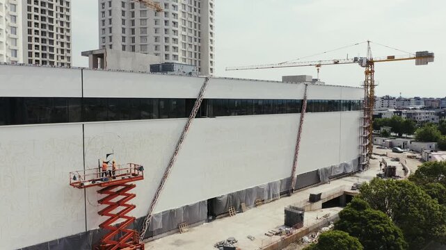 Construction workers on a scissor lift at a building site