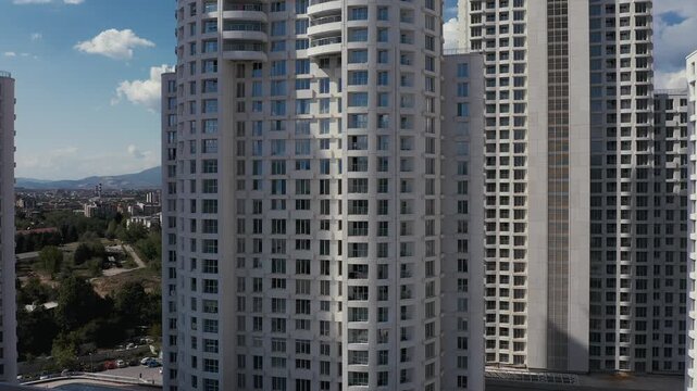 Drone ascending along a modern skyscraper under construction