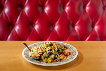 Chinese dish plated with pinions on top against red booth