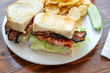 BLT club sandwich cut in half on plate