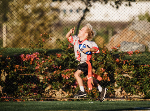 boy celebrating running with a football
