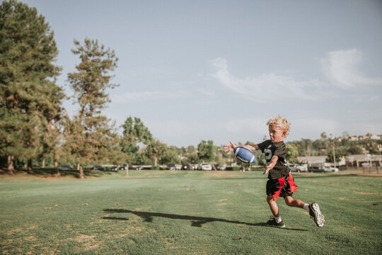 boy practicing flag football about to catch the ball