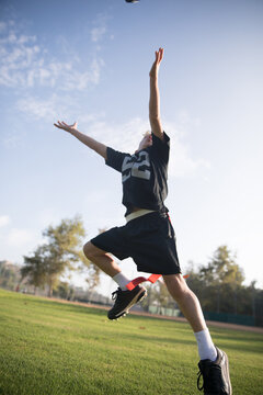 about to catch the ball boy playing flag football