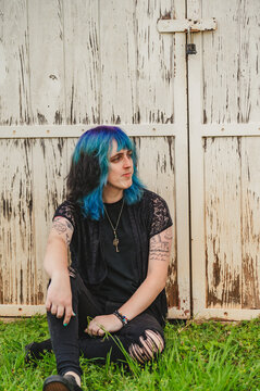 Young Non Binary Person leaning on a locked wooden door