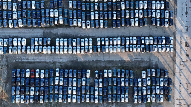 New cars parked in vast lot preparing for distribution