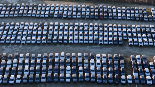 New car inventory organized in rows, a large parking lot