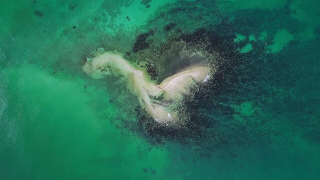 Extreme wide aerial capturing multiple Tondol islands surrounded by crystal clear blue green tropical water.
