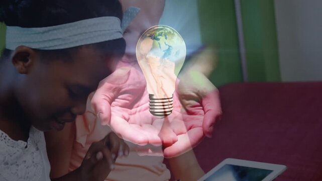 Two students tapping white tablets and swiping, summoning pulsing globe bulb overlay for education